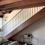 Dulux Dark Bronze wrought iron railing on polished timber staircase with knuckles/knobs, heavy end post and curved end scroll